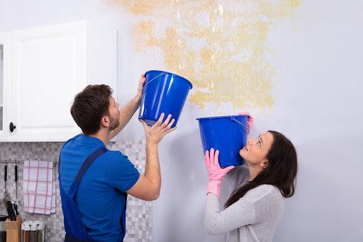 two people holding buckets to catch water